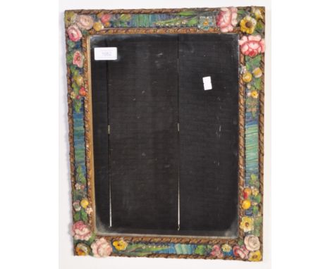 An early 20th century barbola wall mirror. The mirror having hand painted carved cushion frame with continuous patterns of fl