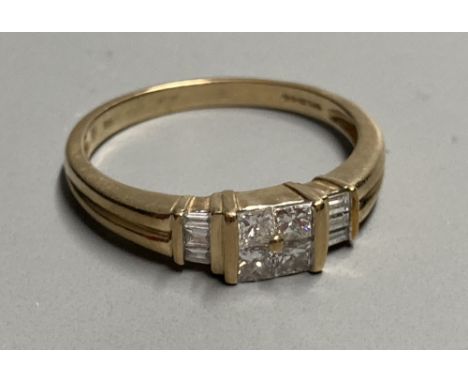 A modern 9ct gold and four stone princess cut diamond cluster ring, with six stone baguette cut diamond set shoulders, size S