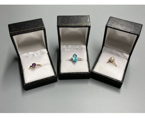 Three assorted modern 9ct or yellow metal and gem set dress rings, including white gold and marquise shaped blue topaz ring, 