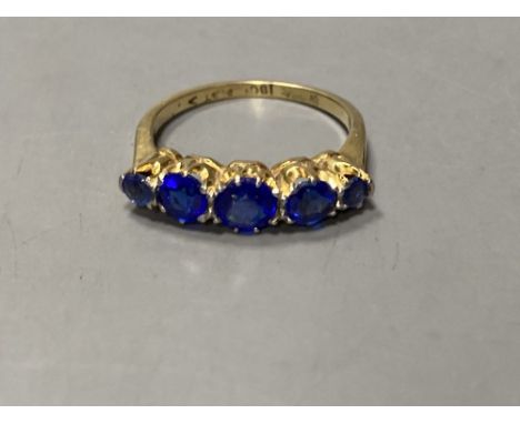 An 18ct and plat. graduated five blue stone doublet half hoop ring, size L, gross 3.1 grams.CONDITION: Two outer stones are r