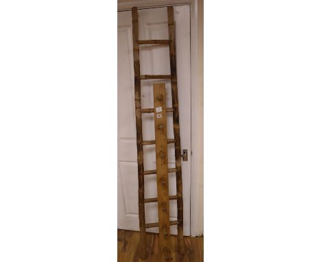 An unusual tapering bamboo seven tread step ladder, 6ft 6in., and a pine wall hanging coat rack