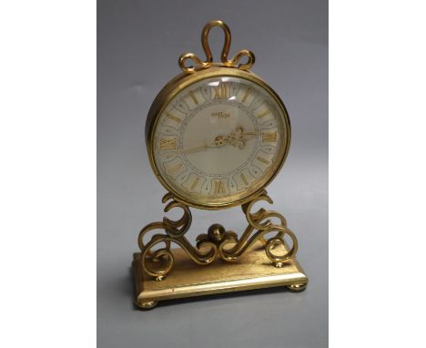 An Imhof vintage gilt brass small mantel clock, having circular Roman dial on scrolled supports and rectangular plinth base, 