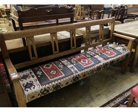 A 19th century Continental oak bench settle, with kelim upholstered seat, width 200cm depth 48cm height 104cm