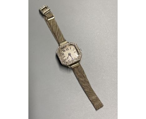 A lady's 1930's white metal and diamond bezel set manual wind wrist watch, on an 18ct mesh link bracelet, gross 16.9 grams (a