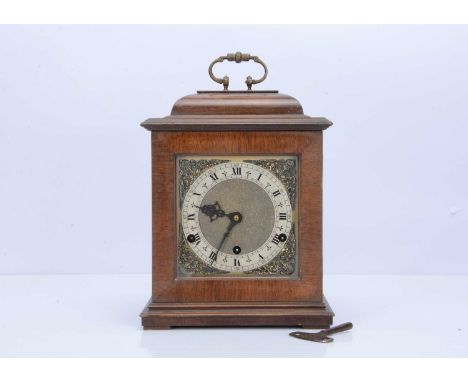 An Edwardian mantle clock, 27.5cm plus handle, appears to be a mahogany case, with square dial and having eight day chiming m