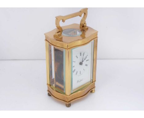 A modern brass carriage clock timepiece from Woodford, 16cm with handle raised, appears in good condition