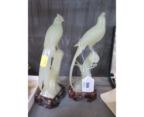 A pair of carved jade figures of exotic birds, on timber stands, 20 cm high, damaged (2) 