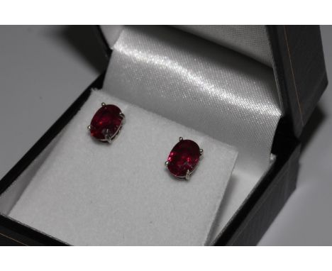 Pair treated oval ruby studs, in silver 