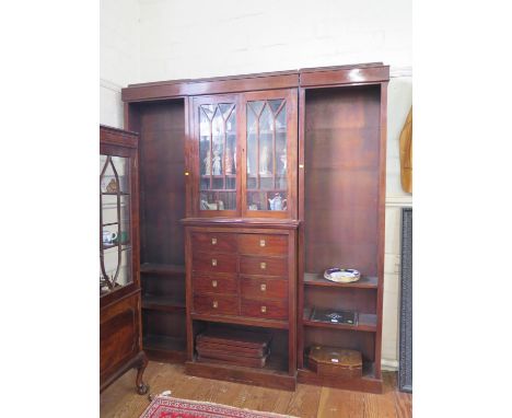 A mahogany breakfront bookcase cabinet, the moulded cornice over a pair of glazed doors above eight short drawers and shelf, 