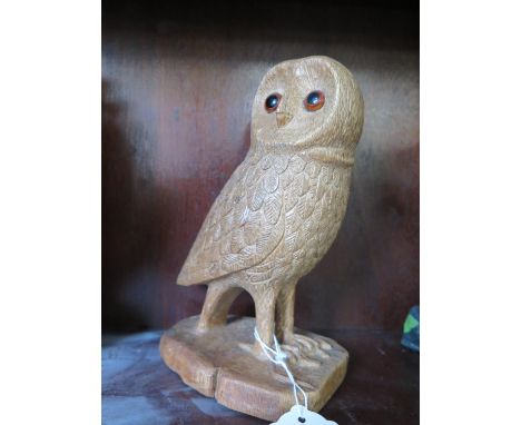 A carved wooden model of an owl standing with a dead mouse both set with glass eyes 