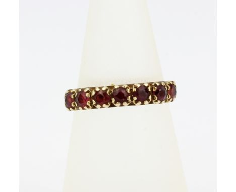 A hallmarked 9ct yellow gold garnet set half eternity ring, (N.5).