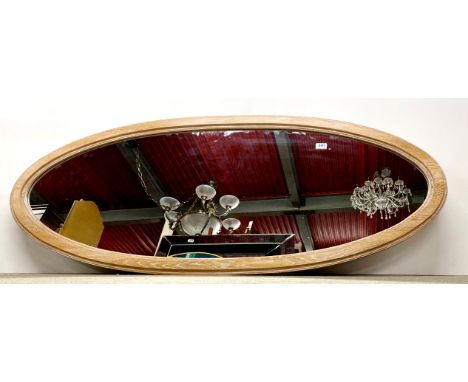 A large contemporary light oak oval mirror, 147 x 61cm.