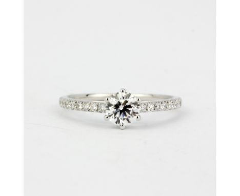 An 18ct white gold (stamped 750) solitaire ring set with a brilliant cut diamond and diamond set shoulders, 0.59ct centre sto