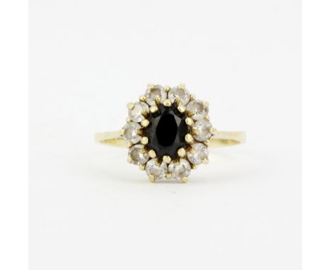 A 14ct yellow gold cluster ring set with an oval cut black stone and white stones, (P).
