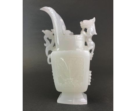 A Chinese carved white jade/hardstone jug shaped item with integral ring decoration and mounted with a young dragon, H. 20cm.