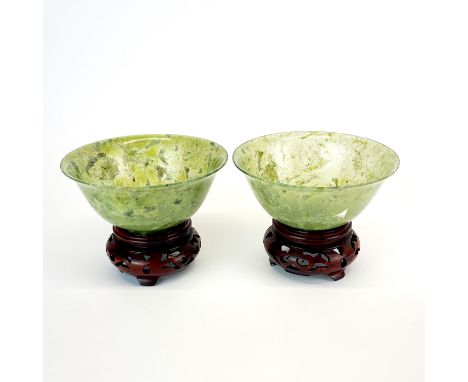 A pair of fine Chinese spinach jade bowls with carved wooden stands, Dia. 10cm.