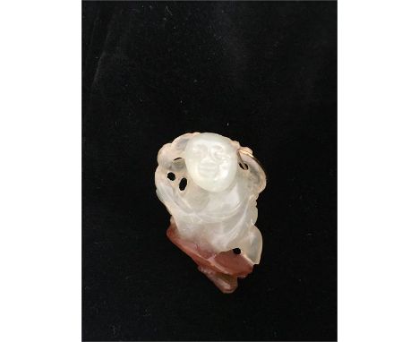A jade netsuke with a gold pin.