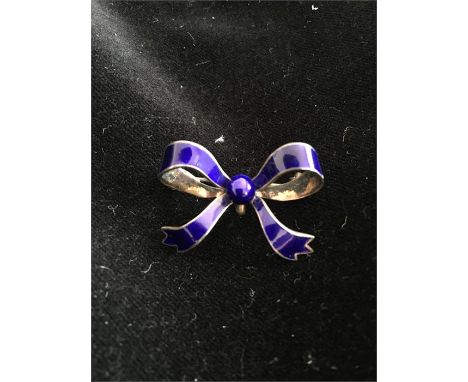 A silver and blue enamel bow shaped brooch