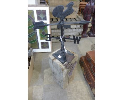 A weather vane on oak plinth and a cast iron bell