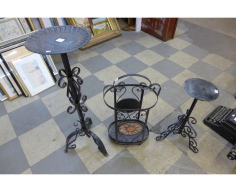 Two wrought iron candle stands and a wrought steel stick stand