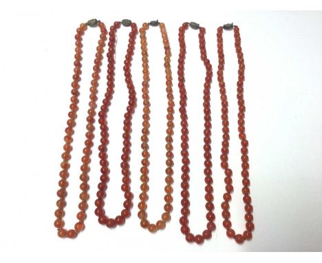Five Chinese carnelian polished bead necklaces with silver clasps. 62cm- 65cm long