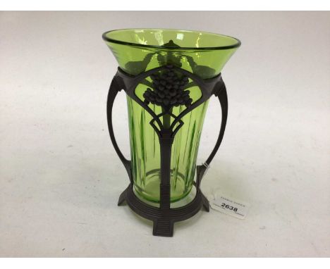 Art Nouveau pewter vase with green glass liner, twin-handled and standing on four feet, 18cm high