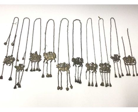 Collection of ten old Chinese silver/white metal pendant necklaces with embossed panels depicting figures riding horses/drago