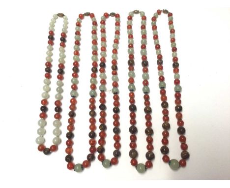 Five Chinese green hard stone and carnelian polished bead necklaces, all with silver gilt clasps. Four measure 76cm long and 
