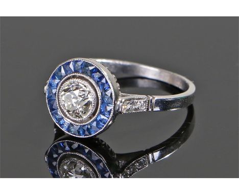 Diamond and sapphire ring, the central diamond at approximately 0.63 carat with a sapphire surround, ring size M