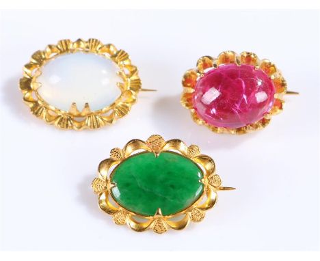 Three yellow metal brooches, set with a moonstone, jade and cabochon red stone, (3)