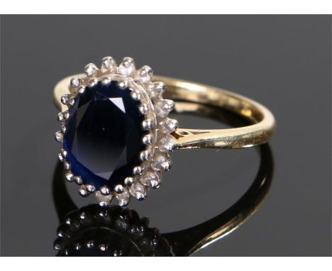 18 carat gold sapphire and diamond set ring, the central sapphire with a diamond edge, ring size R