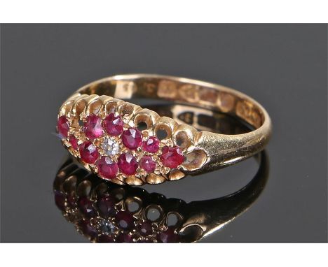 18 carat gold ruby and diamond set ring, the head set with eleven rubies and a central diamond, ring size N
