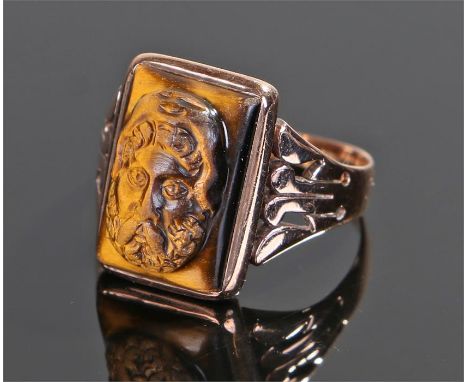 Yellow metal and tigers eye ring, the tigers eye carved as a classical figure with wide shoulders to the shank, ring size O