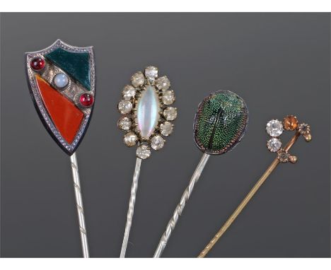 Stick pins, to include a Scottish agate set example, a Egyptian Revival scarab beetle stick pin, two further stick pins and a