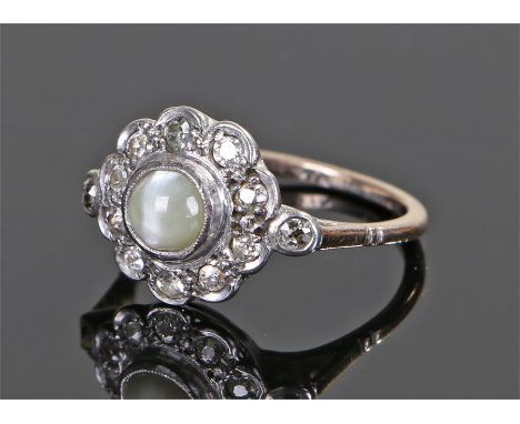 15 carat gold moonstone and diamond set ring, the central moonstone with a surround of thirteen round cut diamonds, ring size
