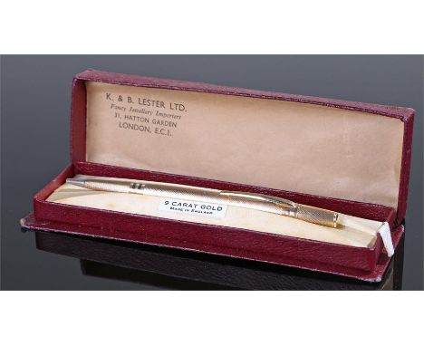 9 carat gold propelling pencil, with an engine turned case, 12cm long