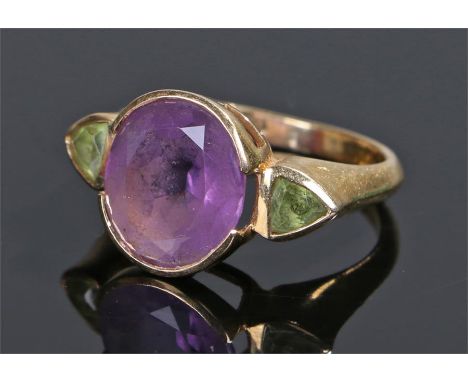 18 carat gold amethyst and peridot ring, the central amethyst with peridot flanking, ring size K