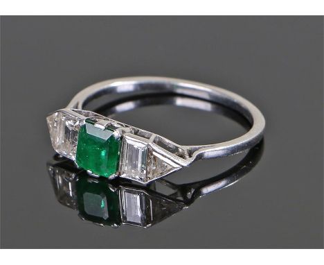 Art Deco diamond and emerald ring, the central, emerald cut, emerald with baguette and triangle cut diamonds flanking, set on