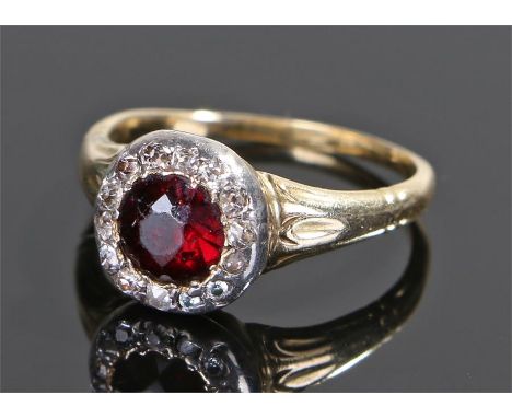 Garnet and diamond set ring, the central garnet with diamond surround, ring size P 1/2