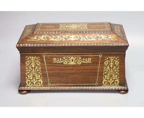 A Regency rosewood and cut brass inlaid sarcophagus shaped tea caddy, (mixing bowl restored), length 33cm
