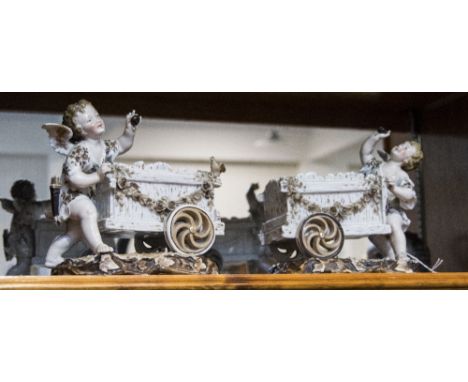 Dresden Late 19th Century Pair of Cherubs Figures with Carts Raised on Naturalistic Bases. Crossed Blue Swords to Underside. 