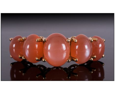 Peach Moonstone Five Cabochon Ring, the largest oval cut cabochon to the centre, measuring 2cts, with two graduated moonstone