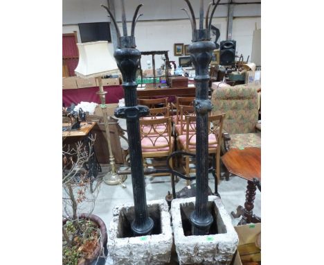 A pair of cast iron street lamp columns together with a pair of garden pots