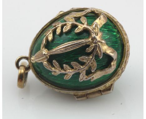 Tests silver enamelled egg pendant, green guilloche enamel with a wreath overlay, hinged with gold gilt, weight 9.1g.