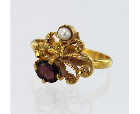 Yellow gold (tests 22ct) garnet and pearl dress ring, one oval garnet measures 6mm x 4mm, one 2.5mm freshwater pearl, head me