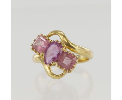 Yellow gold (tests 18ct) pink sapphire trilogy ring, principle pear cut measures 8mm x 5mm, flanked with one step cut either 
