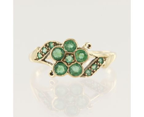 Yellow gold (tests 9ct emerald cluster dress ring, set with twelve variously sized round emeralds, head measures 9mm, finger 