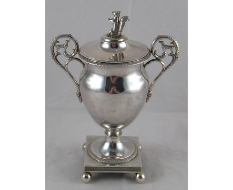 A French silver two handled cup and cover with beaded and acanthus borders, the urn with spread foot on a square base with ba