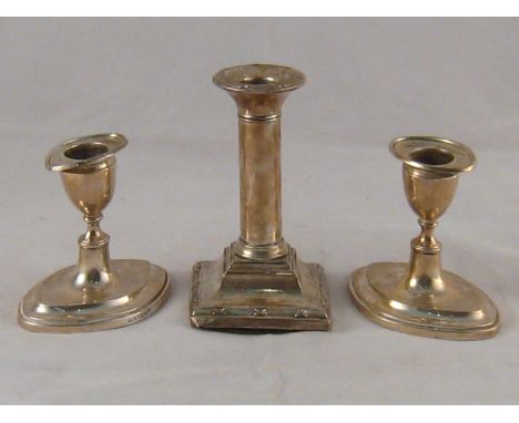 A pair of dwarf silver candlesticks in the Adam manner, Sheffield, 1904, ht. 9cm. , and a single Doric column silver candlest