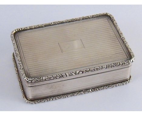 A George IV gilt lined silver snuff box with reeded finish to all faces and applied enrichments to lid and base, the inside o